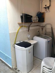 a bathroom with a sink and a washing machine at Refúgio Azul na Praia - Itaipuaçu-RJ in Maricá