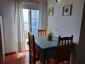 a dining room with a table and chairs and a window at Apartamento junto al mar La Baja in Santa Cruz de Tenerife