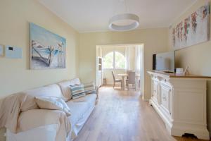 a living room with a white couch and a table at Pellicano Suite Apartment in Marina di Grosseto