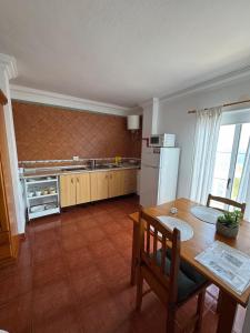a kitchen with a table and a refrigerator at Apartamento junto al mar La Baja in Santa Cruz de Tenerife +5 photos