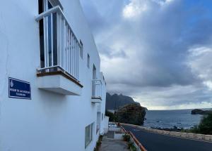 a white building with a window and the ocean at Apartamento junto al mar La Baja in Santa Cruz de Tenerife