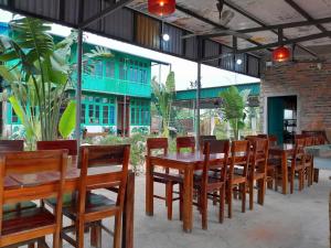 a dining room with wooden tables and chairs at Mina Café & Stay in Quan Lạn