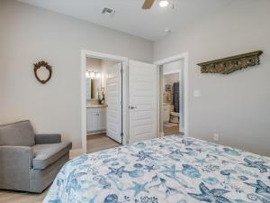 a bedroom with a bed and a chair and a bathroom at Nauta Mirage in Rockport +30 photos