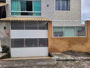 una porta bianca in garage su un edificio di mattoni di Casa do aconchego cohab1 a Garanhuns