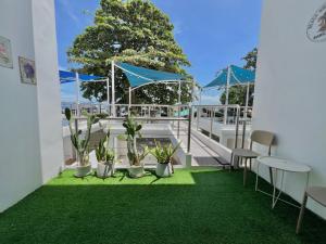 a patio with green grass and plants on a balcony at Beach home pool villa bangsaray in Bang Sare