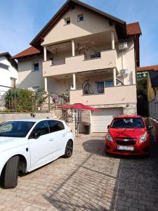two cars parked in front of a house at Apartments Dani in Postojna