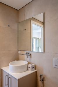 a bathroom with a sink and a mirror at Apeiron Blue Perissa Apartments in Perissa