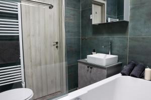 a bathroom with a white sink and a toilet at Heroes Apartment Esztergom in Esztergom