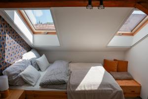 a bedroom with two beds and two windows at Heroes Apartment Esztergom in Esztergom