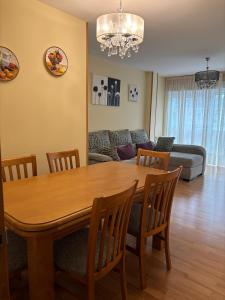 un salon avec une table et des chaises en bois dans l'établissement Alojamiento Morriña, à O Pedrouzo