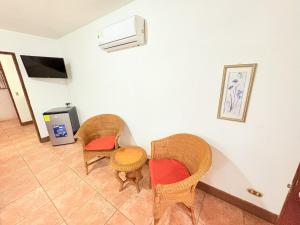 two wicker chairs and a table in a room at Hotel Villa Acacia in Playa Hermosa
