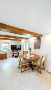 Una sala de estar con una mesa y sillas de madera. en Przy Strumyku - Apartament w Górach Izerskich, en Kłopotnica