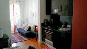里斯本的住宿－Casa Estrela，厨房以及带蓝色沙发的客厅。