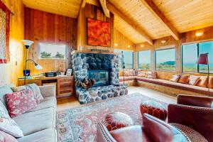 a living room with a stone fireplace in a house at Cadwalader House in Sea Ranch