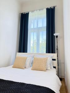 a bedroom with a bed with blue curtains and a window at Apartment Hviezdko - Heart of Old Town in Bratislava