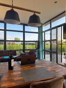 a dining room with a table with a laptop on it at Marina Strandbad Chalet IJssel Oase mit Zaun Haus Nr 77 in Olburgen
