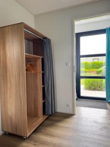 a closet in a room with a large window at Marina Strandbad Chalet IJssel Oase mit Zaun Haus Nr 77 in Olburgen +32 photos