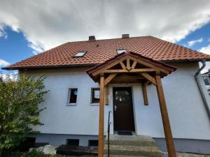 a white house with a red roof and a door at Odea Ferienhaus in Soltau