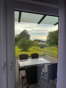 a table and chairs on a patio with a window at Odea Ferienhaus in Soltau