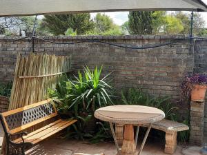 a table and a bench and a table and an umbrella at Kalahari Kaja in Kuruman