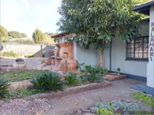 a house with a statue in front of a yard at Kalahari Kaja in Kuruman