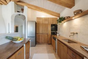 a kitchen with wooden cabinets and a bowl of fruit on the counter at Discesa a mare - Lussuosa Villa a 180 sul Mare in Villaggio Piras