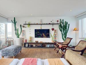 a living room with two chairs and a tv at Lux 12 - Cobertura Romantica com piscina aquecida e vista mar in Rio de Janeiro