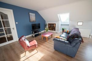 a living room with a couch and two chairs at The Swilly Suite in Castlequarter