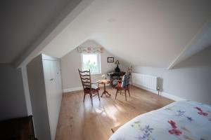 a bedroom with a bed and a table and chairs at The Swilly Suite in Castlequarter