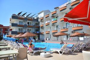 埃尔代克Sare Hotel的酒店拥有游泳池,游泳池里的人坐在椅子上