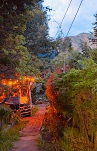a pathway leading to a house with trees and lights at Cabaña en la Calera Ciprés in La Calera +29 photos