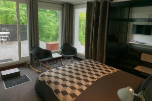 a bedroom with a bed and chairs and a window at Casa mARTa : Suites, terrasses et vue panoramique in Tournon-sur-Rhône