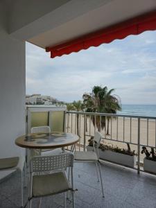 a balcony with a table and chairs and the ocean at Beach view apartment in Cullera in Cullera