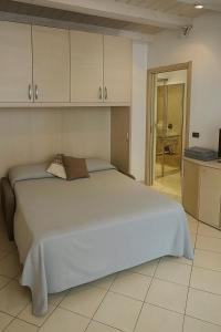 a bedroom with a large bed and a kitchen at Rossi Lake Couple in Oliveto Lario