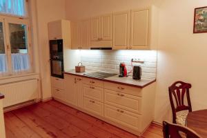 a kitchen with white cabinets and a counter top at Aparmány Rozálie in Česká Lípa +11 photos