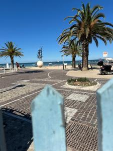 a street with palm trees and the beach at Alessandra House in Grottammare