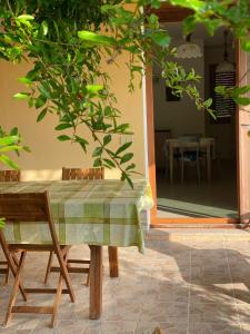 - une table et des chaises sur une terrasse avec une maison dans l'établissement Appartamento Salvatore Caletta sul mare, à La Caletta 15 autres photos