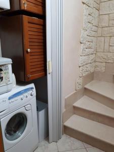 a laundry room with a washing machine and a staircase at Residenza Borgo Antico in Termoli
