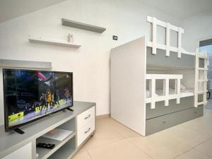 1 dormitorio y sala de estar con TV de pantalla plana. en Elisabeth Apartments 2, en Sarandë