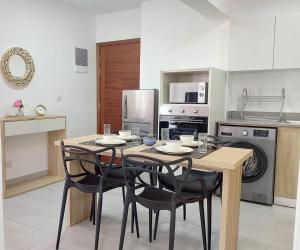 a kitchen with a table and chairs in a kitchen at Modern and Luxury 3 bedroom apartment Steps from the beach in Flic-en-Flac