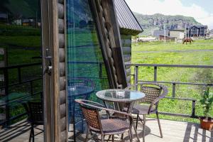 un patio avec une table et des chaises sur un balcon dans l'établissement Kokhta Cottage Kazbegi 2, à Kazbegi