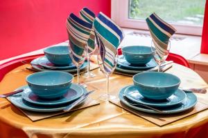 a table with plates and bowls and wine glasses at Edinburgh Drumdryan Central Apartment in Edinburgh