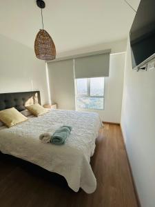 リマにあるdepartamento de estreno con espectacular vistaのベッドルーム1室(ベッド1台、緑のタオル付)