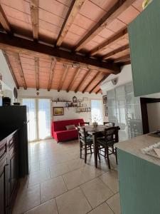 cocina y sala de estar con mesa y sofá rojo en Tenuta De Fanti Agriturismo, en Bibbona