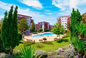 an apartment complex with a swimming pool in a park at Sveti Vlas Fort Noks Panorama SAS in Sveti Vlas