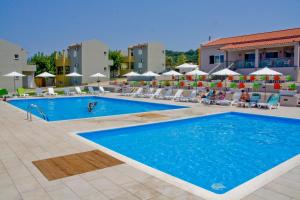 a pool at a hotel with people sitting around it at Fournia Village in Kyllini