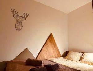 um quarto com uma cama e uma cabeça de veado na parede em Studio Apartman Nomad Divčibare em Divčibare