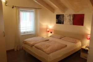 a bedroom with a bed and a window at Appartamenti Lilia - Ledro in Tiarno di Sopra +101 photos