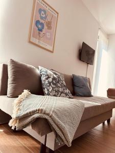a couch with a blanket on it in a living room at Studio Apartman Nomad Divčibare in Divčibare