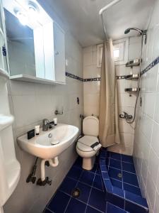 ネア・カリクラティアにあるCentral Beach Apartmentの洗面台とトイレを備えた白いバスルーム